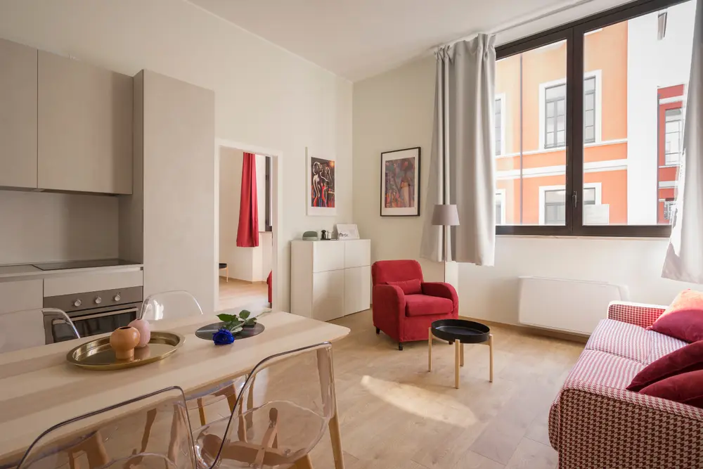 Light-filled apartment with a red armchair, ready for guests